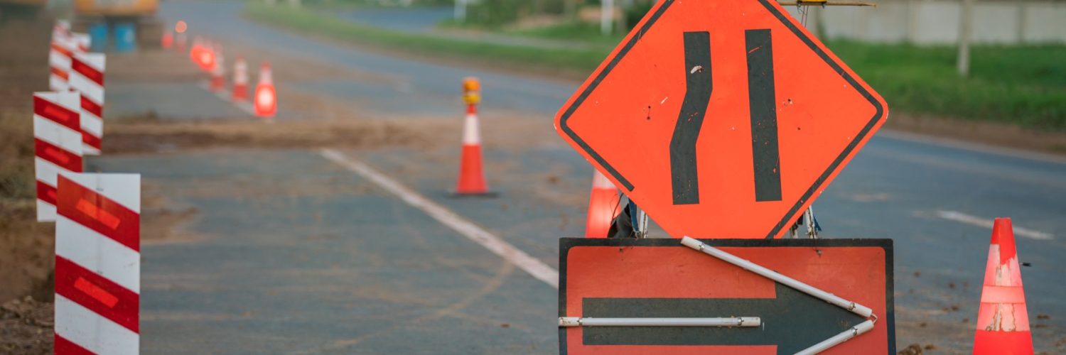 Along a section of the road are the signals for construction. It has a sign that the lanes are narrowing and cones.
