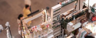 Overhead view of three displays side-by-side at an indoor pop-up shop, each displaying various trinkets to sell.
