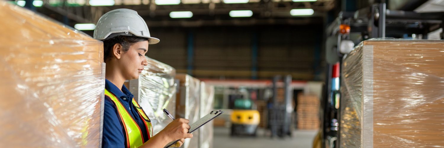 A group of individuals wearing suits reviews charts and solar panels on a table while one person holds a small globe.